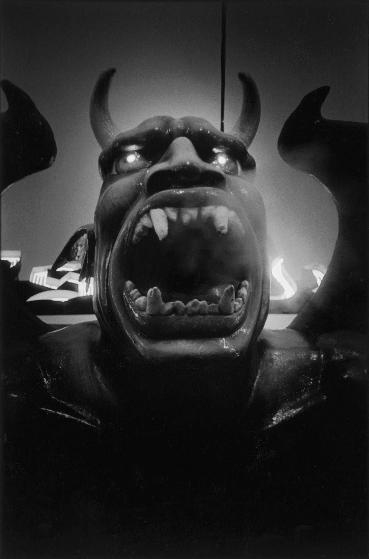 Close-up of a monster’s head with large teeth and horns.