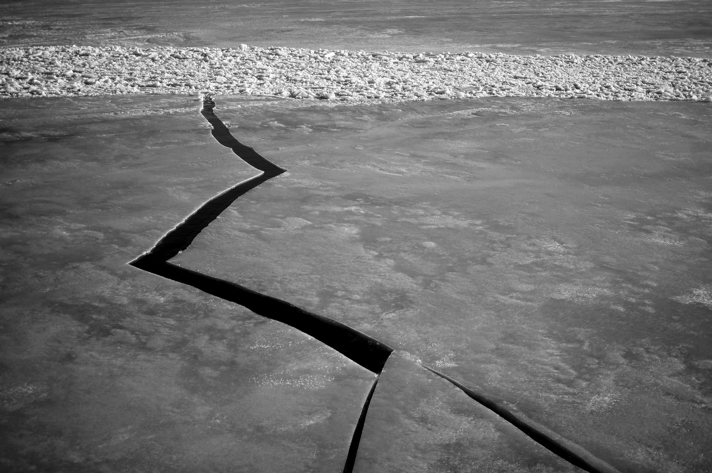 A body of water covered with ice with a large zigzag crack seen from a ferry on a trip from Hiumaa back to Tallinn, Estonia.