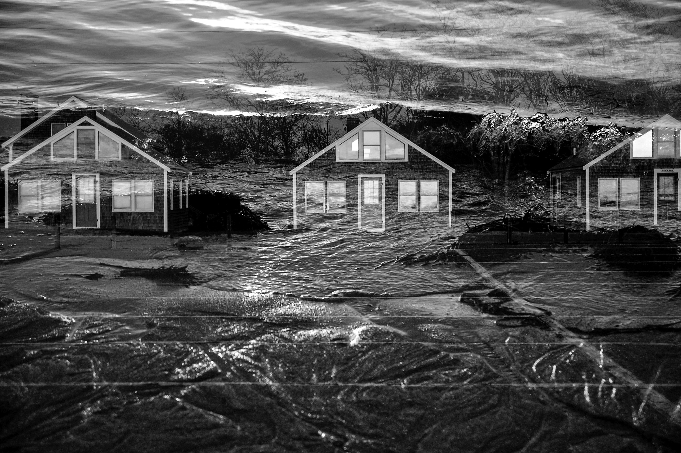 A composite image of two digital photos taken at Corn Hill Beach in Truro, Massachusetts, to address the global-warming crisis shows three similar two-story houses during a flood.