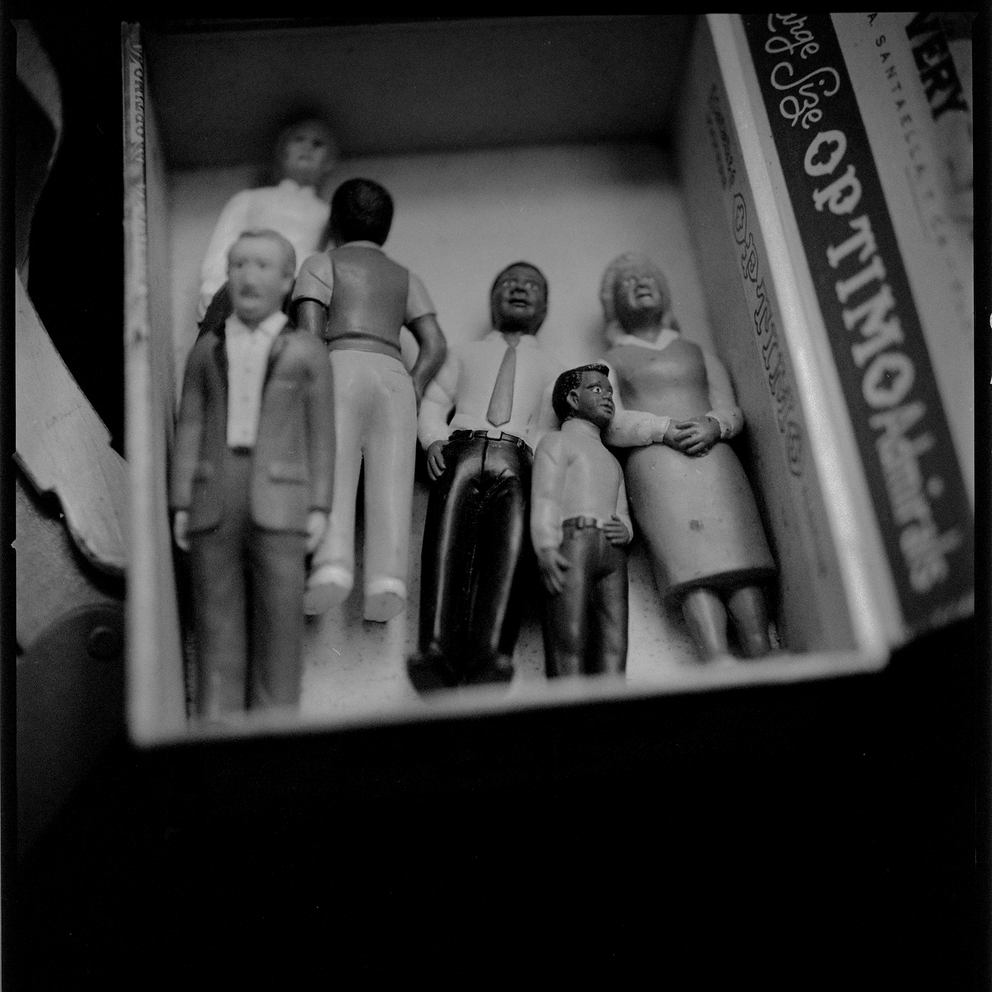 Six surprisingly well-dressed plastic adult male and female figurines in a cigar box at a New York City flea market.