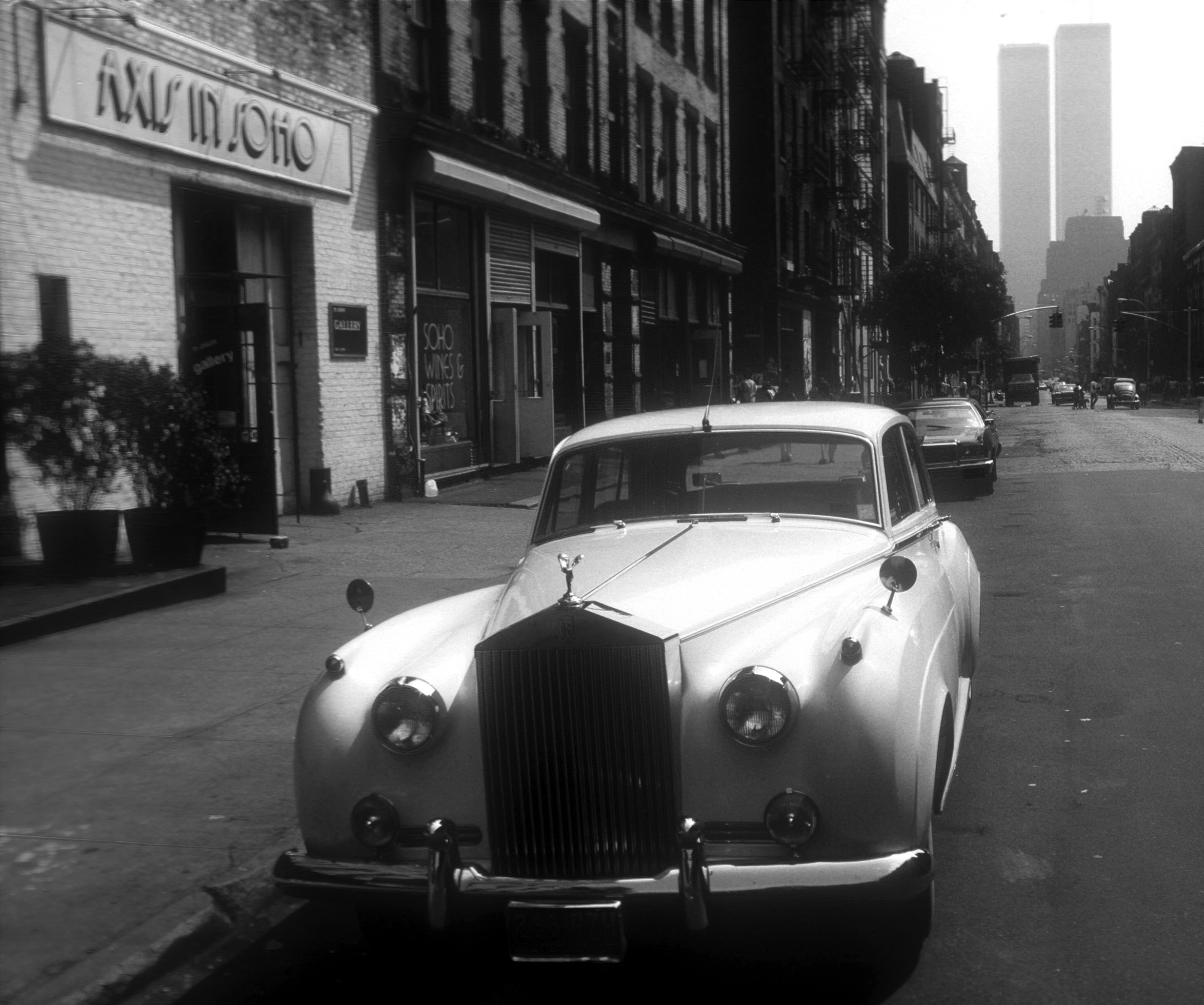 A white Rolls-Royce is parked near Axis in SoHo and facing the camera on West Broadway and Houston Street, in the SoHo District, Manhattan.