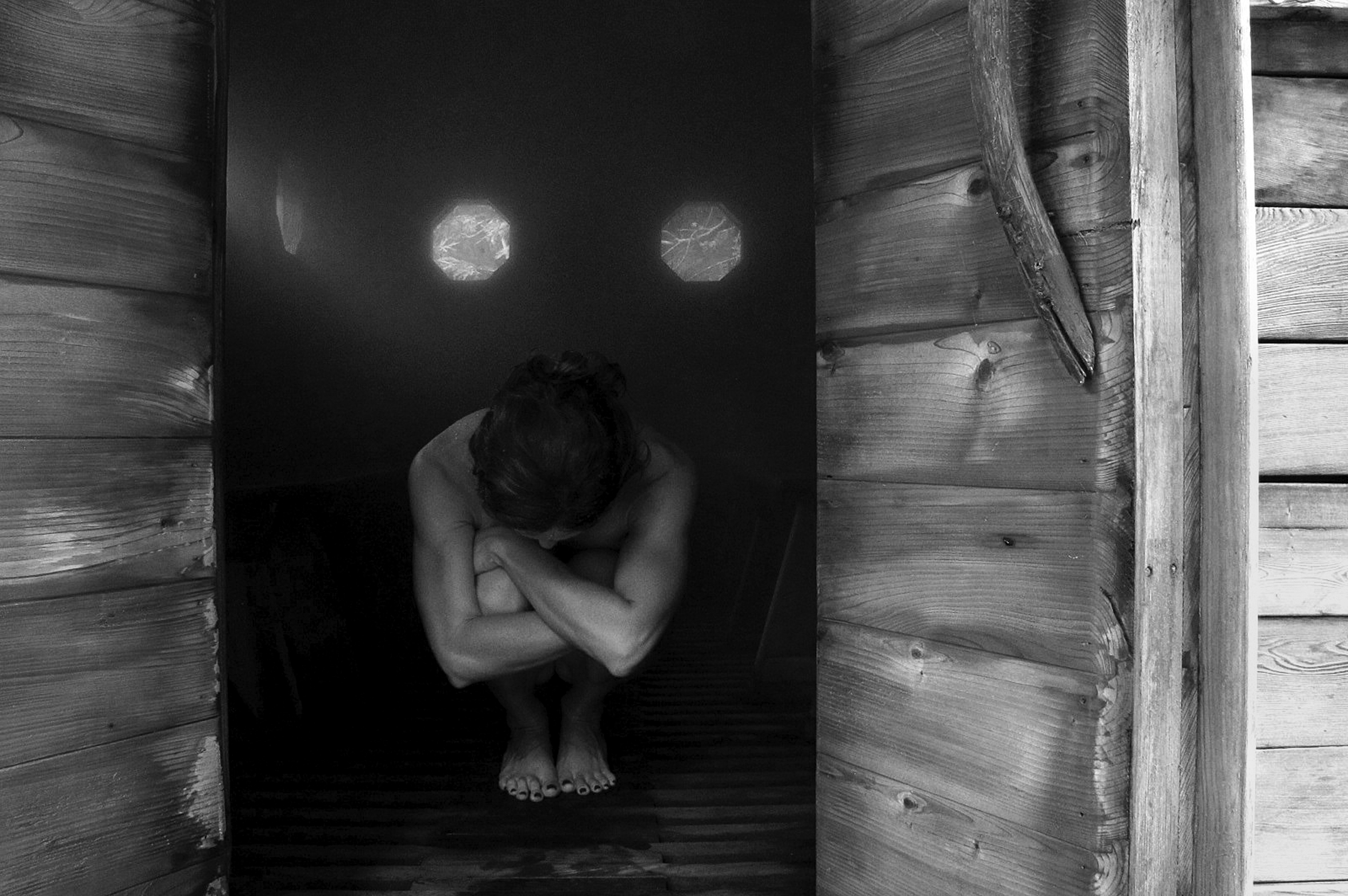 A woman crouches down with her arms around her knees in a steam area at Breitenbush Hot Springs just outside of Salem, Oregon, during her morning ritual while at the hot springs: steam, soak, and a silent breakfast to begin the day.