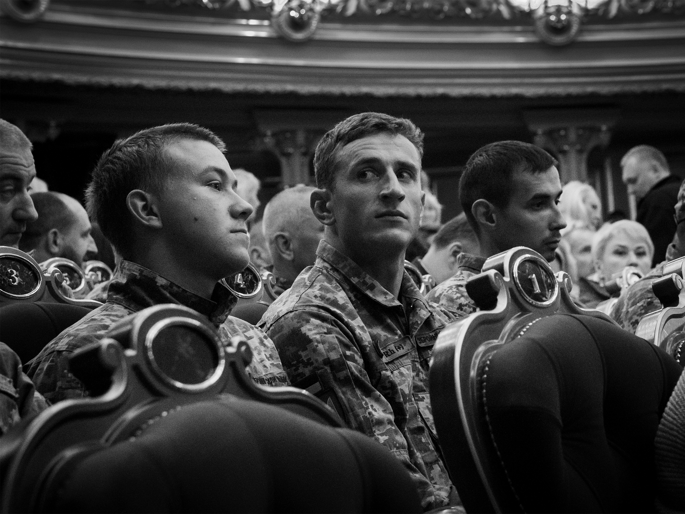 Ukrainian military members seated in an ornate theater.