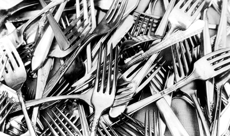 A disorganized pile of flatware forks.