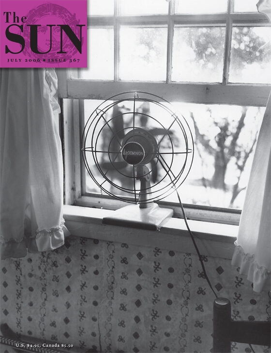 July 2006 cover of The Sun. A Dominion brand antique fan sits on the windowsill of an old farmhouse. The window framed by white curtains with a ruffled edge is open to the height of the fan. The top of a wooden chair peeks up from the bottom right.