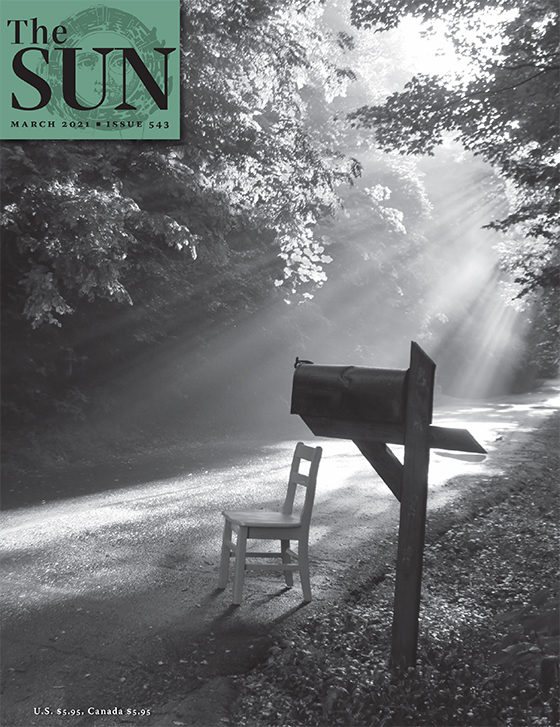 Cover of Issue 543. A wooden chair sits along a path next to a mailbox with a ray of sunlight hitting the chair.