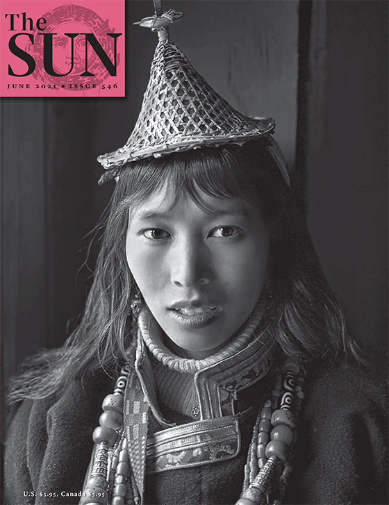 A portrait of a woman from Bhutan who is dressed in her regional wear including a triangular hat.
